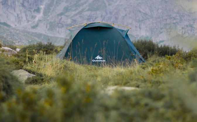 A green tent in the middle of a field