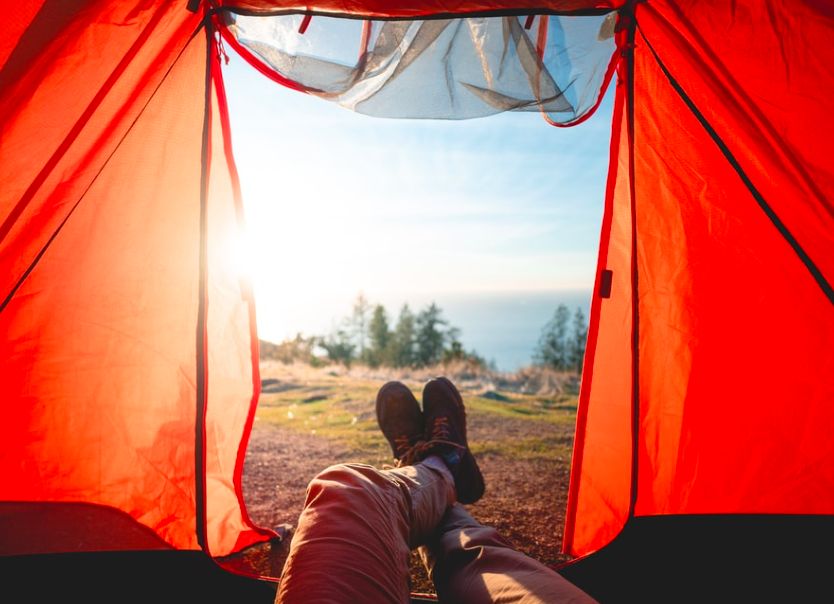 The view from a tent door, showing the blue sky and a mountain top