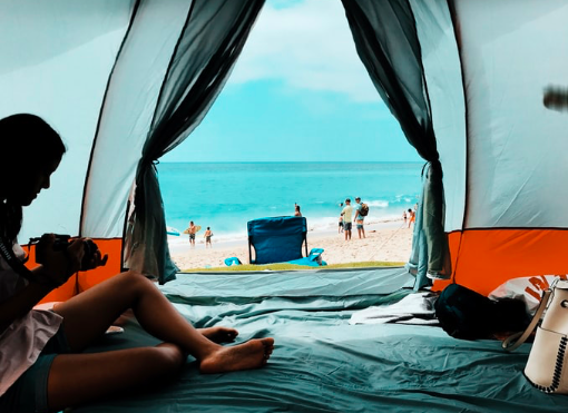 Two people sat in a tent on the beach