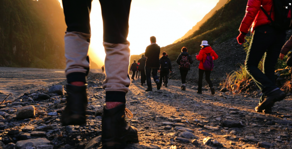 A group of people in hiking gear walking along a rocky path