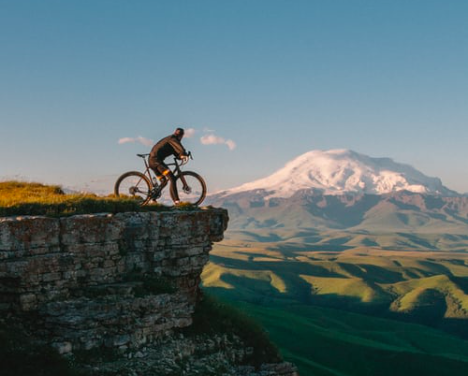 A man on a bike looking at the view over a mountain