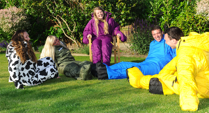 Friends sat outside wearing Sleeping Bag Suits