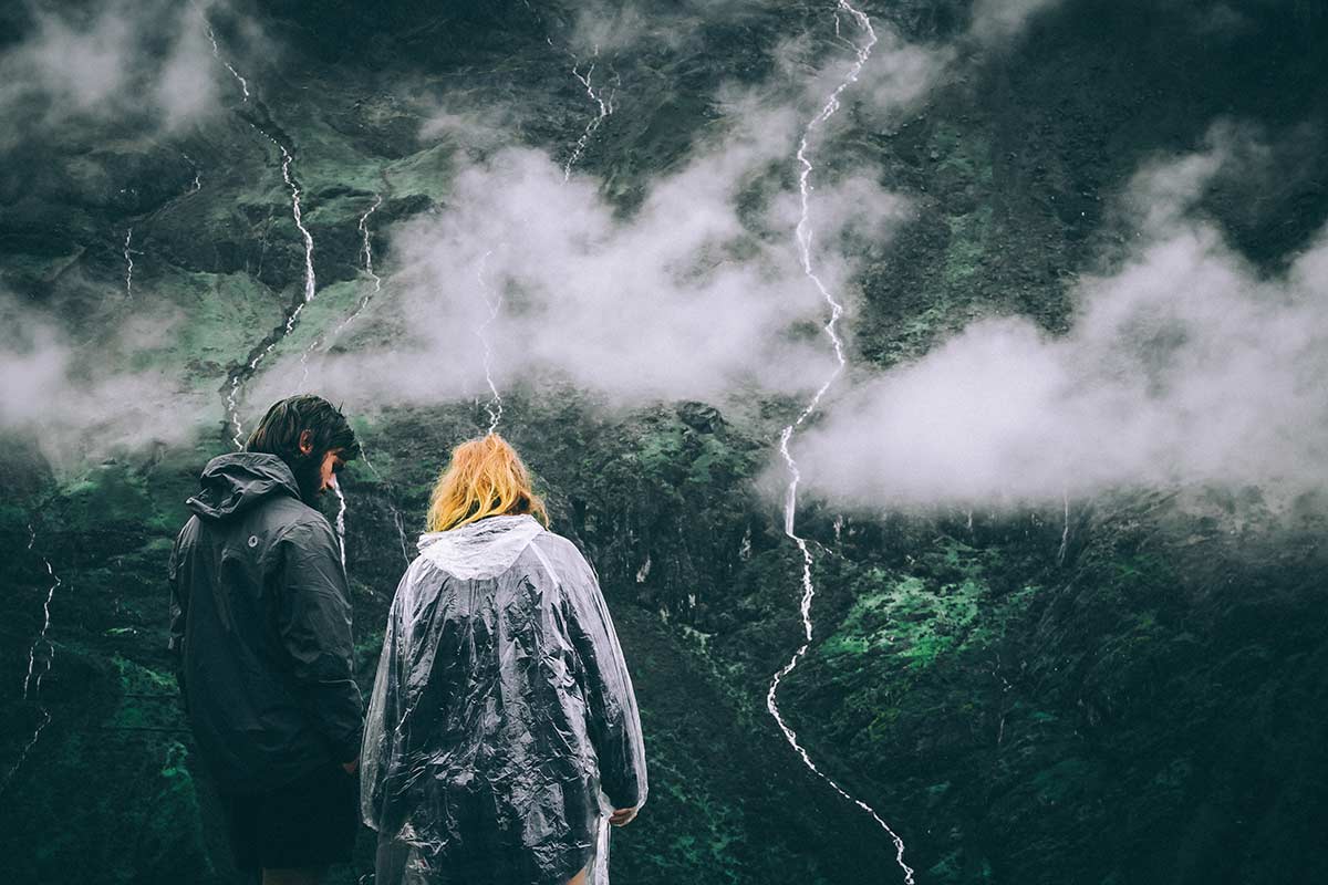 A couple wearing wet weather clothing while camping